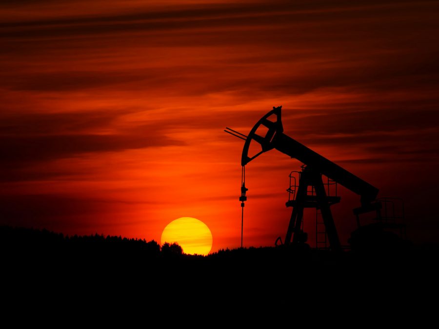 Pumpjack silhouetted against a deep red sunset on a remote lease, an isolated site that needs solid grounding and lightning protection